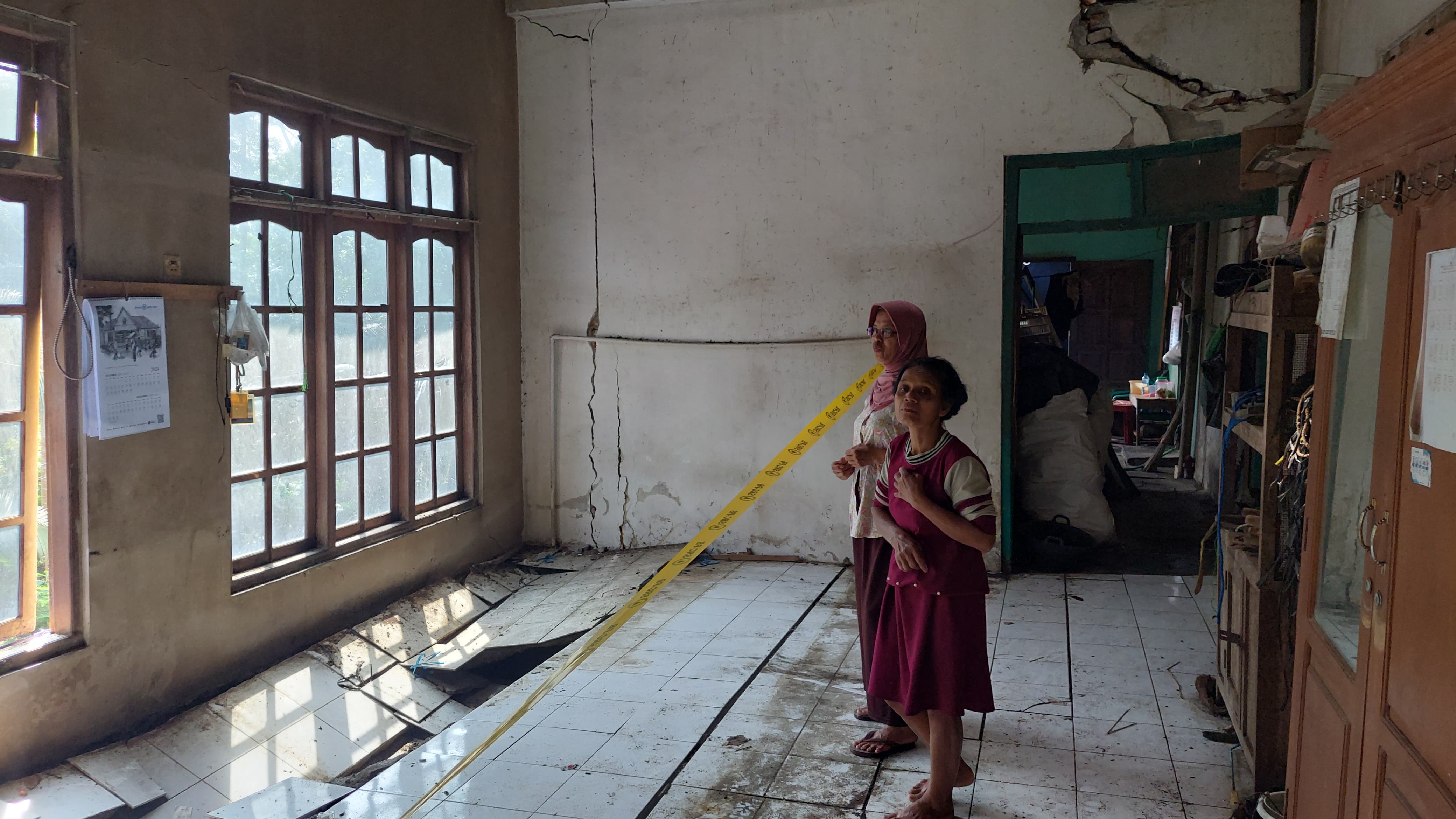 AMBLAS: Surohmi menunjukkan bekas amblas dan terbelah bangunan rumah miliknya.&nbsp;