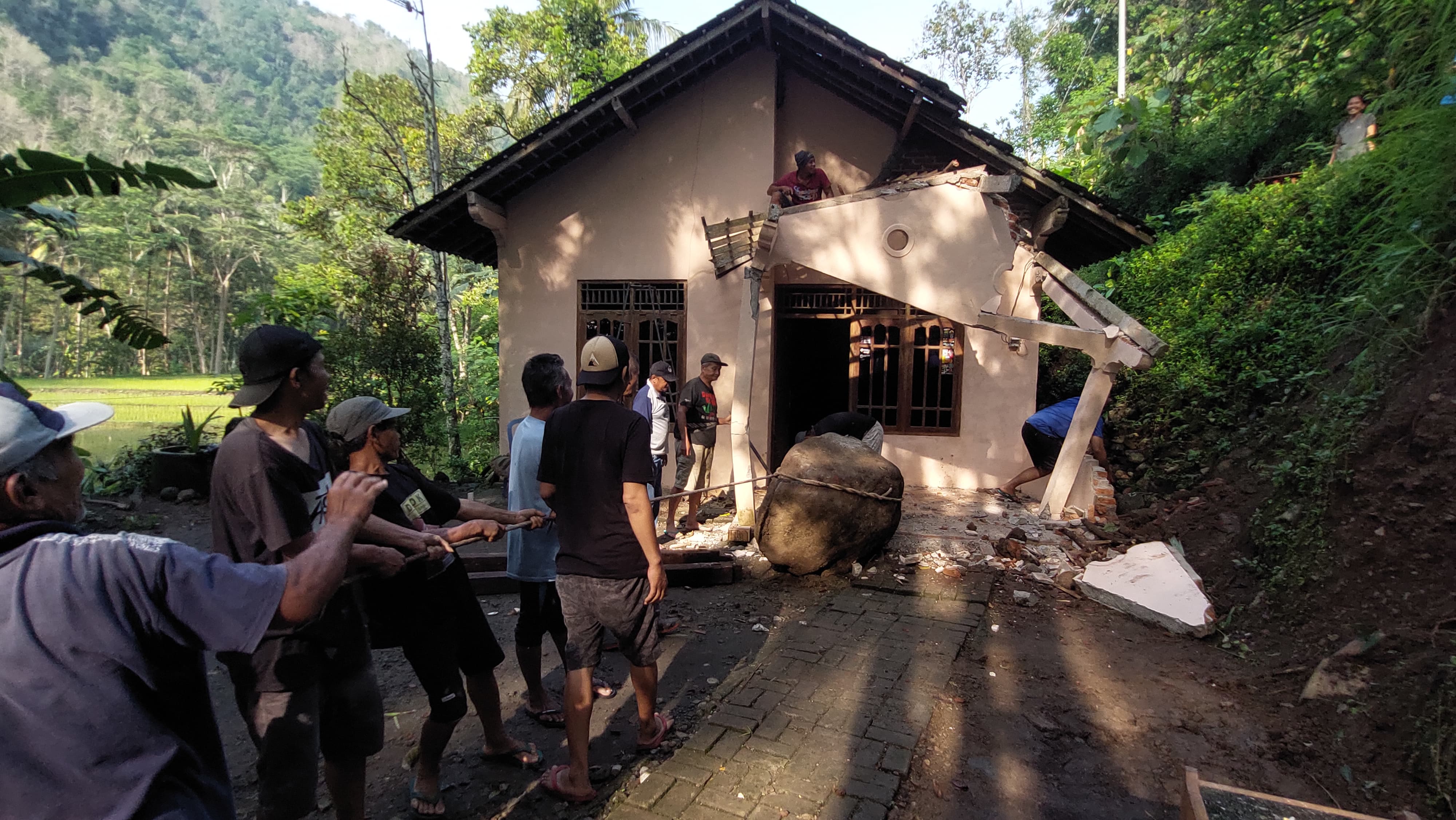 KERJA BAKTI: Warga memindahkan batu ukuran 1 meter di depan rumah.&nbsp;