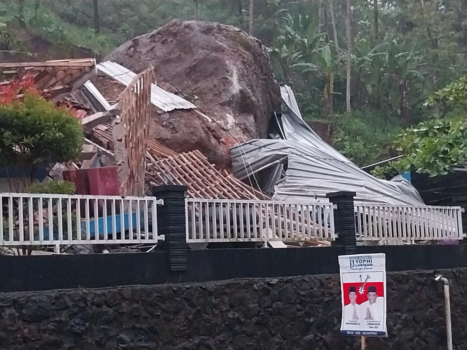 ISTIMEWA Sebuah batu raksasa tampak menimpa sebuah rumah hingga kondisinya rusak parah, Selasa (19/11).