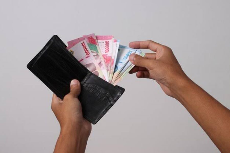 Berlembar-lembar uang tersedia di dompet.