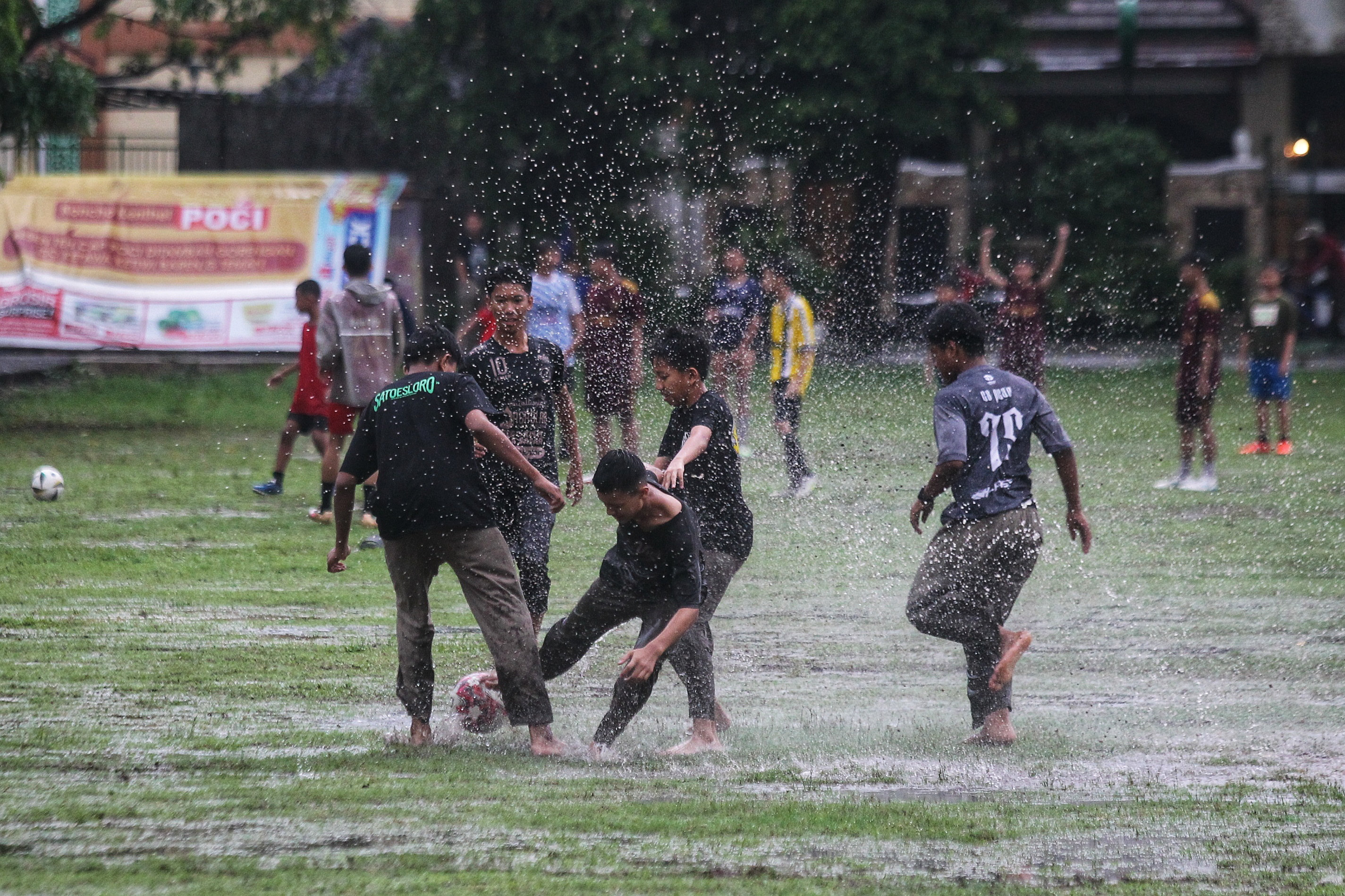 Sejumlah remaja bermain bola saat hujan mengguyur Lapangan Mancasan, Kemantren Wirobrajan, Kota Jogja, Kamis (21/11).