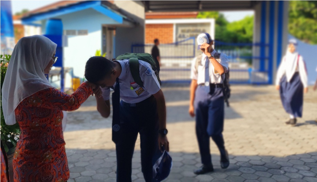 ADAB - Sebelum masuk kelas sejumlah siswa SMP di Jogja terlihat mencium tangan tenaga pendidik