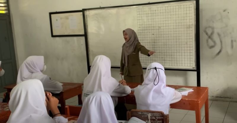 Guru mengajar di kelas.