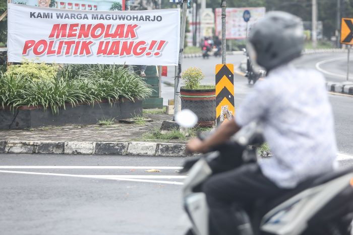 SIKAP TEGAS: Spanduk berisikan penolakan politik uang terpasang di ring road utara kawasan Maguwoharjo, Depok, Sleman Selasa (26/11/2024).