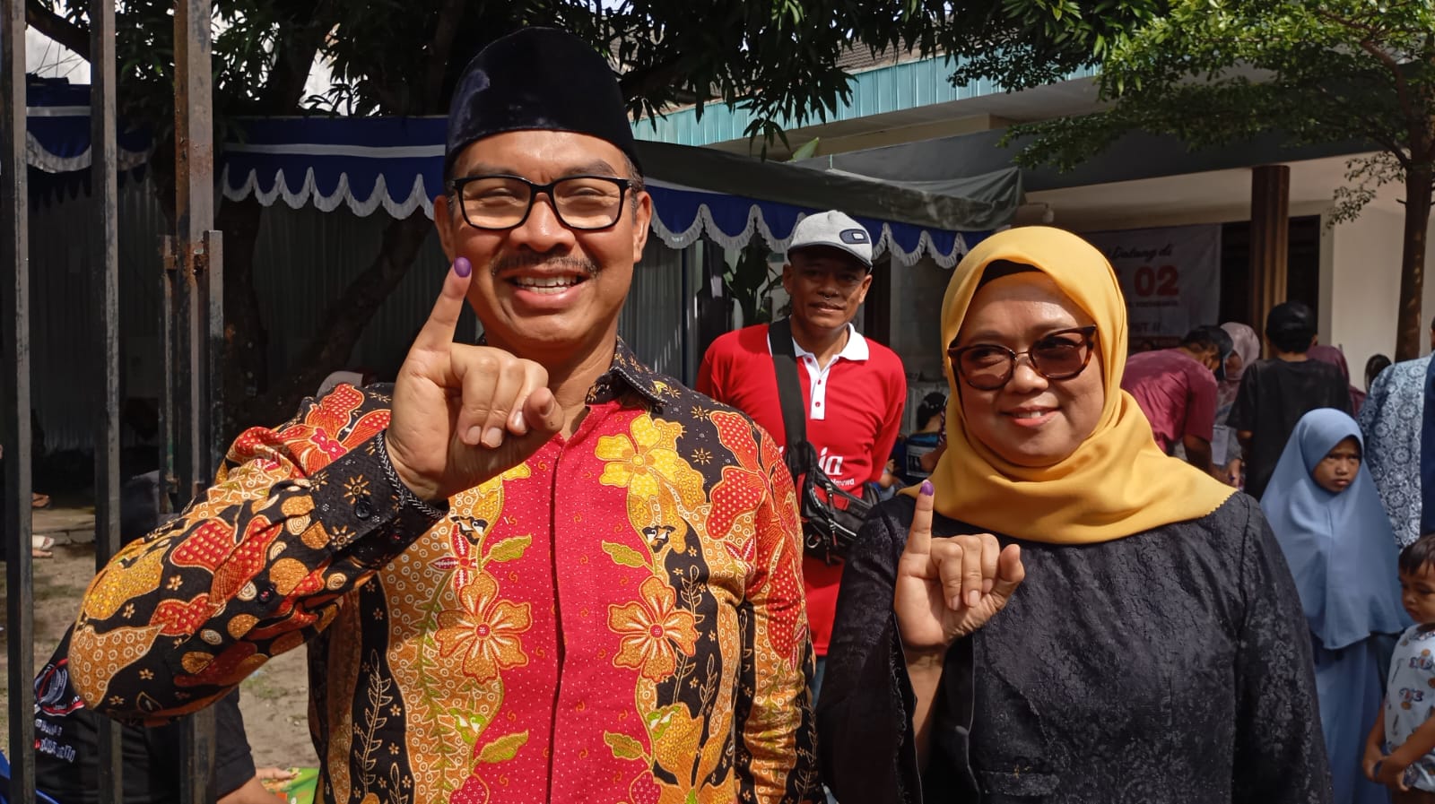 Hasto Wardoyo bersama istrinya saat menunjukkan jarinya seusai mencoblos di TPS 01 Giwangan, Umbulharjo, Kota Jogja pada Rabu (27/11/2024).  &nbsp;