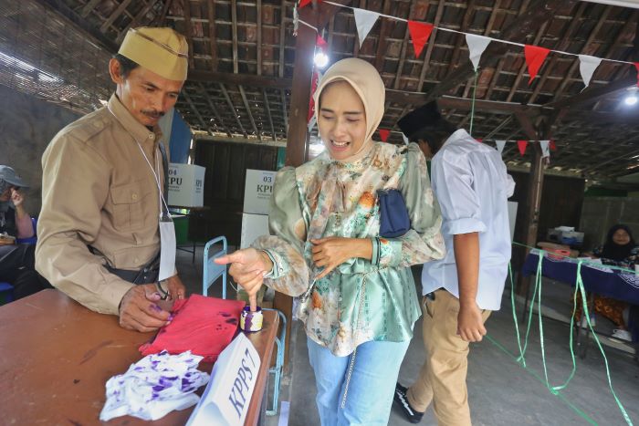 Petugas mengenakan pakaian perjuangan saat bertugas di TPS 45, Maguwoharjo, Depkk, Sleman, Rabu (27/11). TPS itu mengusung tema perjuangan kemerdekaan untuk menarik perhatian warga