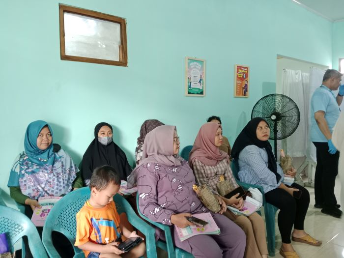 Ibu hamil yang tengah melakukan pemeriksaan kesehatan dan akan diberikan makan bergizi
