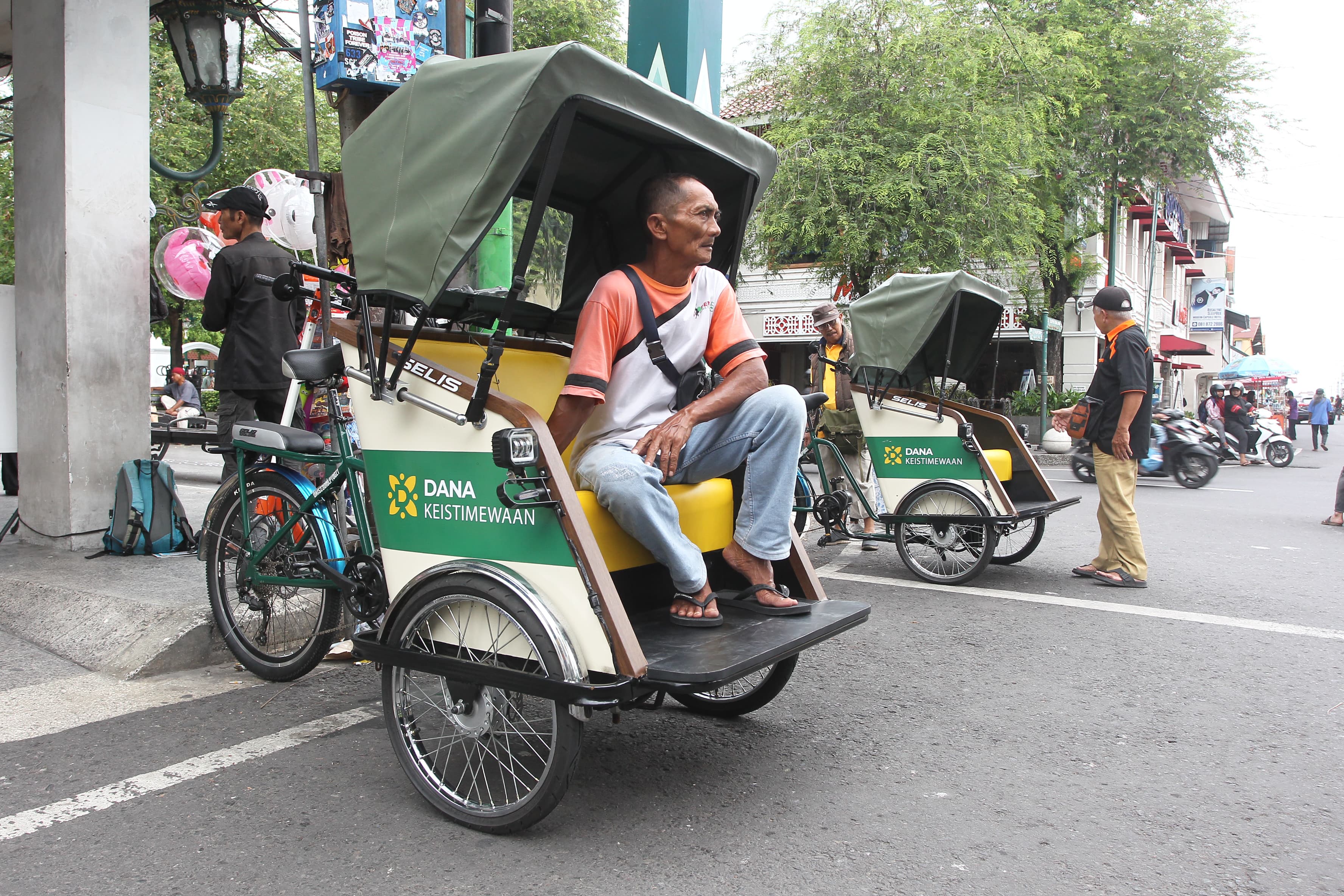 Pengemudi becak kayuh listrik menunggu calon penumpang di kawasan Malioboro, Kota Jogja, Selasa (3/12).
