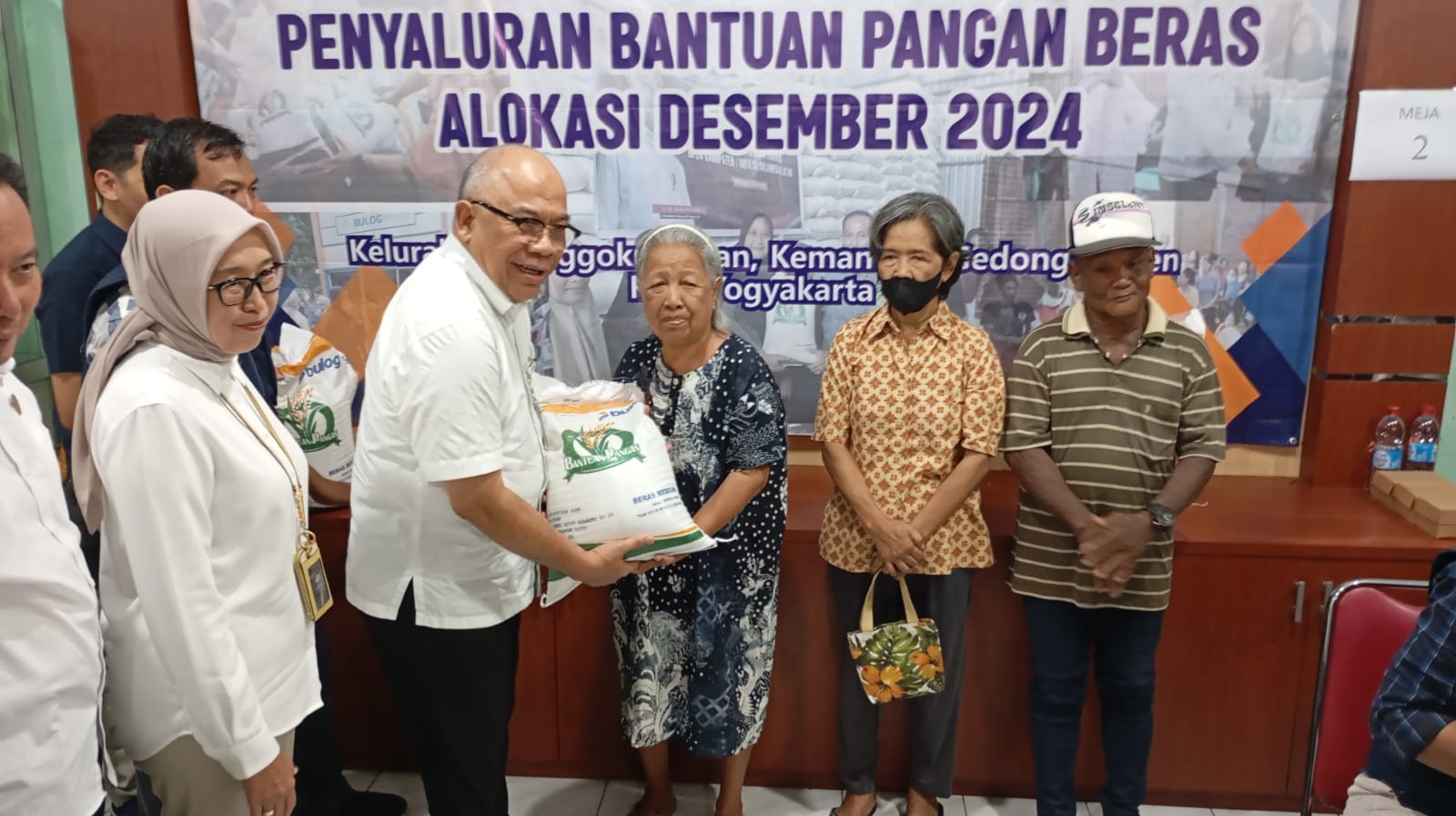 Direktur Utama Perum Bulog Wahyu Suparyono saat menyerahkan bantuan beras gratis kepada warga Pringgokusuman Jogja, Rabu (4/12/2024).  (IWAN NURWANTO/Radar Jogja)