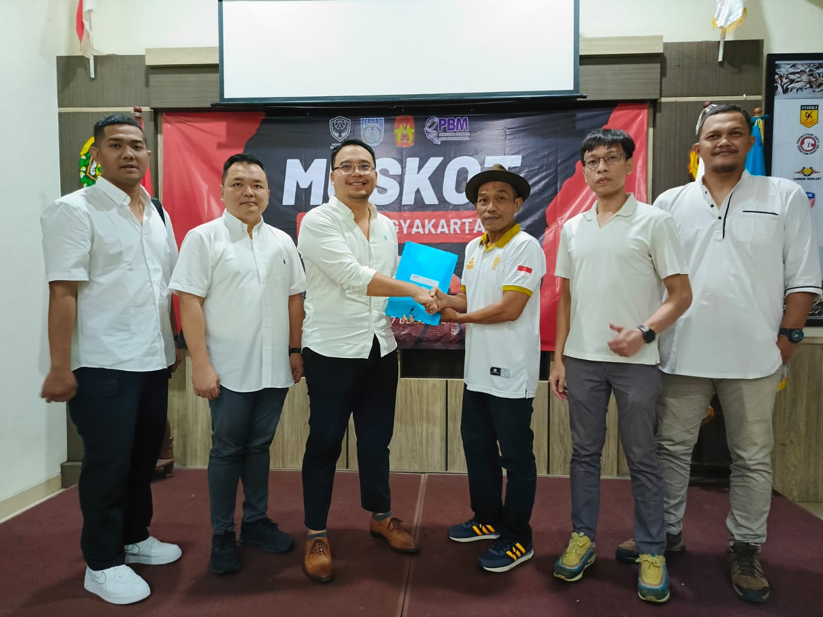 Leonardo Niko Tirtono (tiga dari kiri) saat menerima surat keputusan hasil pemilihan pada Muskot Perbasi Kota Jogja dari pimpinan sidang, Rachmad Kasim Martadji di Aula KONI Kota Jogja, Sabtu (7/12).