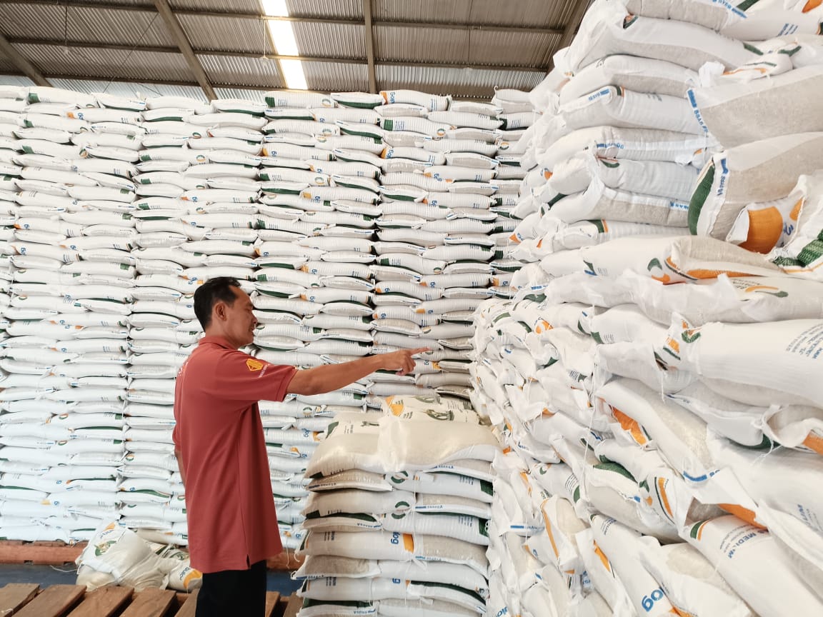 STOK AMAN : Kepala Gudang Bulog Kebumen Sidik Sugiharto menunjukkan tumpukan stok beras di gudang. Dia menyebut saat ini ketersediaan beras masih sekitar 2.800 ton.