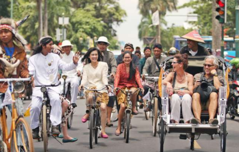 Turis jalan-jalan keliling Jogja dengan transportasi tradisional.