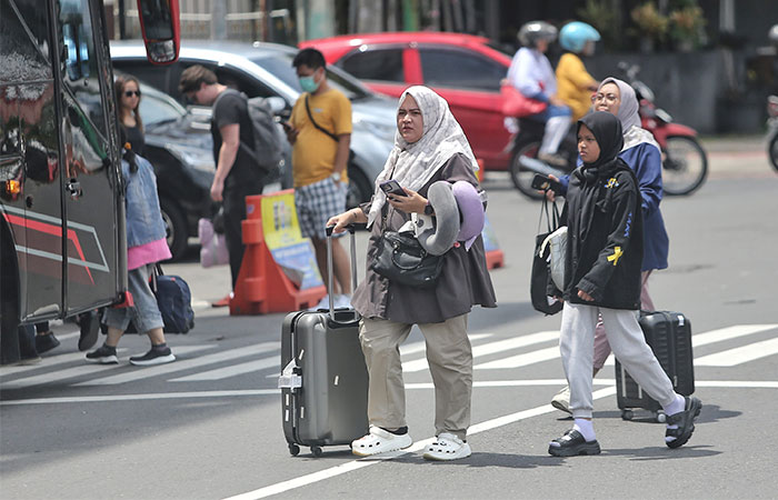 Wisatawan keluar dari Stasiun Jogjakarta dengan membawa tas koper di kawasan Jalan Pasar Kembang, Jogja, Sabtu (21/12). PHRI DIJ mencanangkan target okupasi hotel lebih tinggi dari tahun lalu sebesar