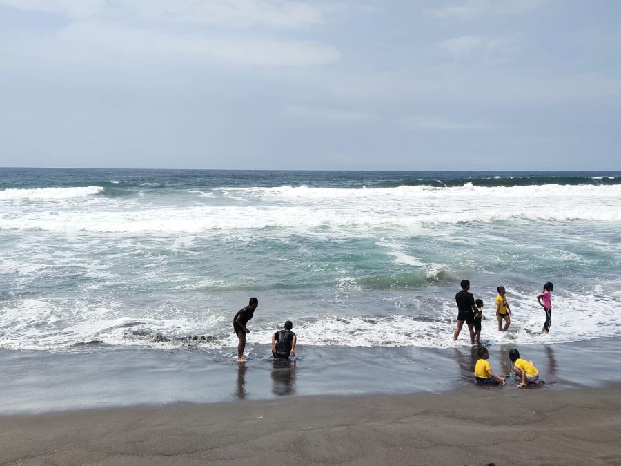 Pengujung Pantai Dewaruci Jatimalang Purworejo bermain air di tepi pantai libur nataru tahun lalu.