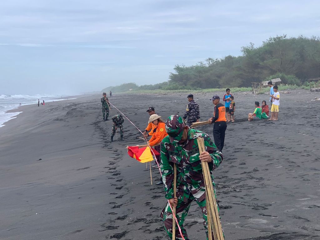 ANTISIPASI: Dinporapar Purworejo bersama tim gabungan memasang batas pengunjung agar tidak bermain atau mandi di laut, Rabu (25/12