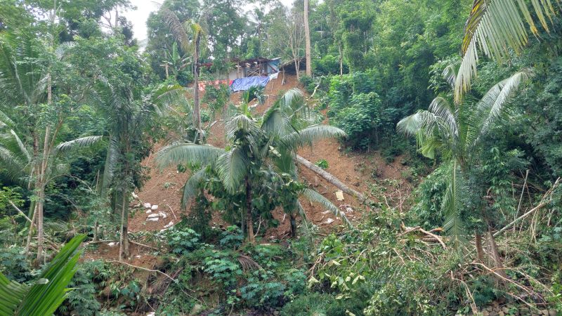 TEBING: Warga kerja bakti memungut puing bangunan yang terbawa material longsor.&nbsp;