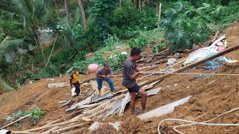 TEBING: Warga kerja bakti memungut puing bangunan yang terbawa material longsor.&nbsp;