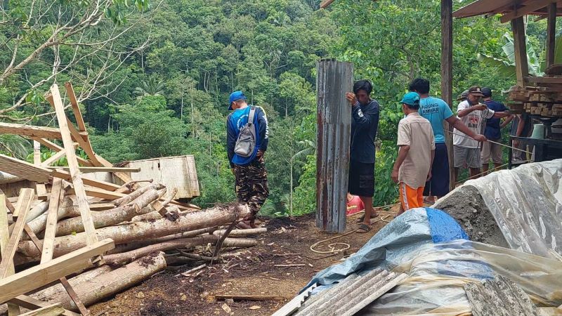 TEBING: Warga kerja bakti memungut puing bangunan yang terbawa material longsor.