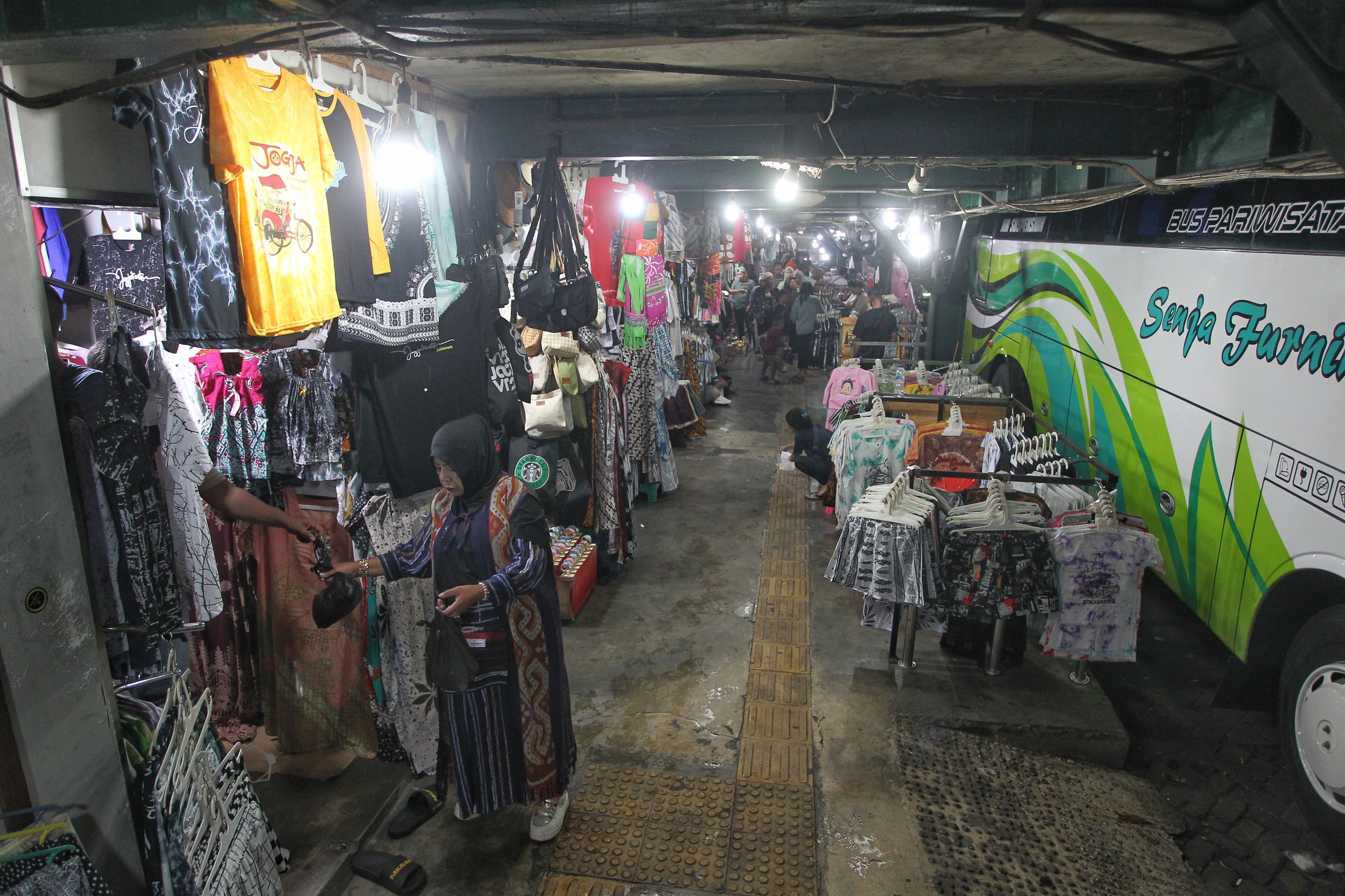 Wisatawan membeli cinderamata yang dijual di area Taman Khusus Parkir Abu Bakar Ali, Kota Jogja, Kamis (26/12). Kenaikan Pajak Pertambahan Nilai (PPN) 12 persen berpotensi besar menurunkan daya beli