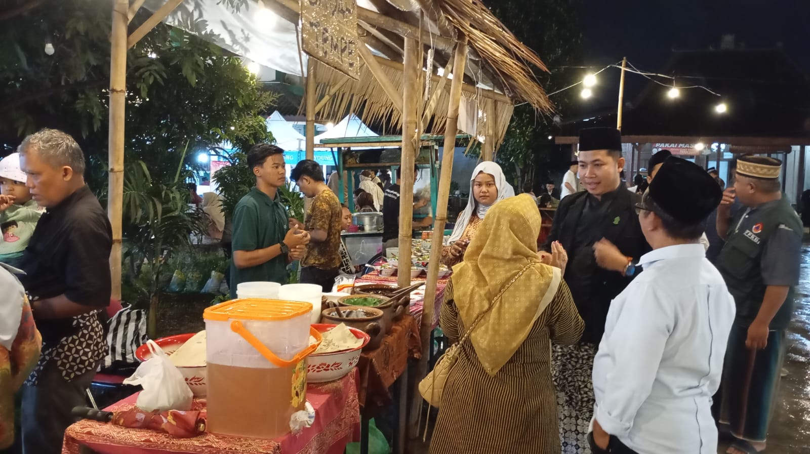 MAYORAN : Pengunjung saat melihat-lihat makanan gratis yang disajikan dalam tradisi mayoran di Festival Kampung Santri 2024, Sabtu (28/12/2024) malam.  (IWAN NURWANTO/Radar Jogja)