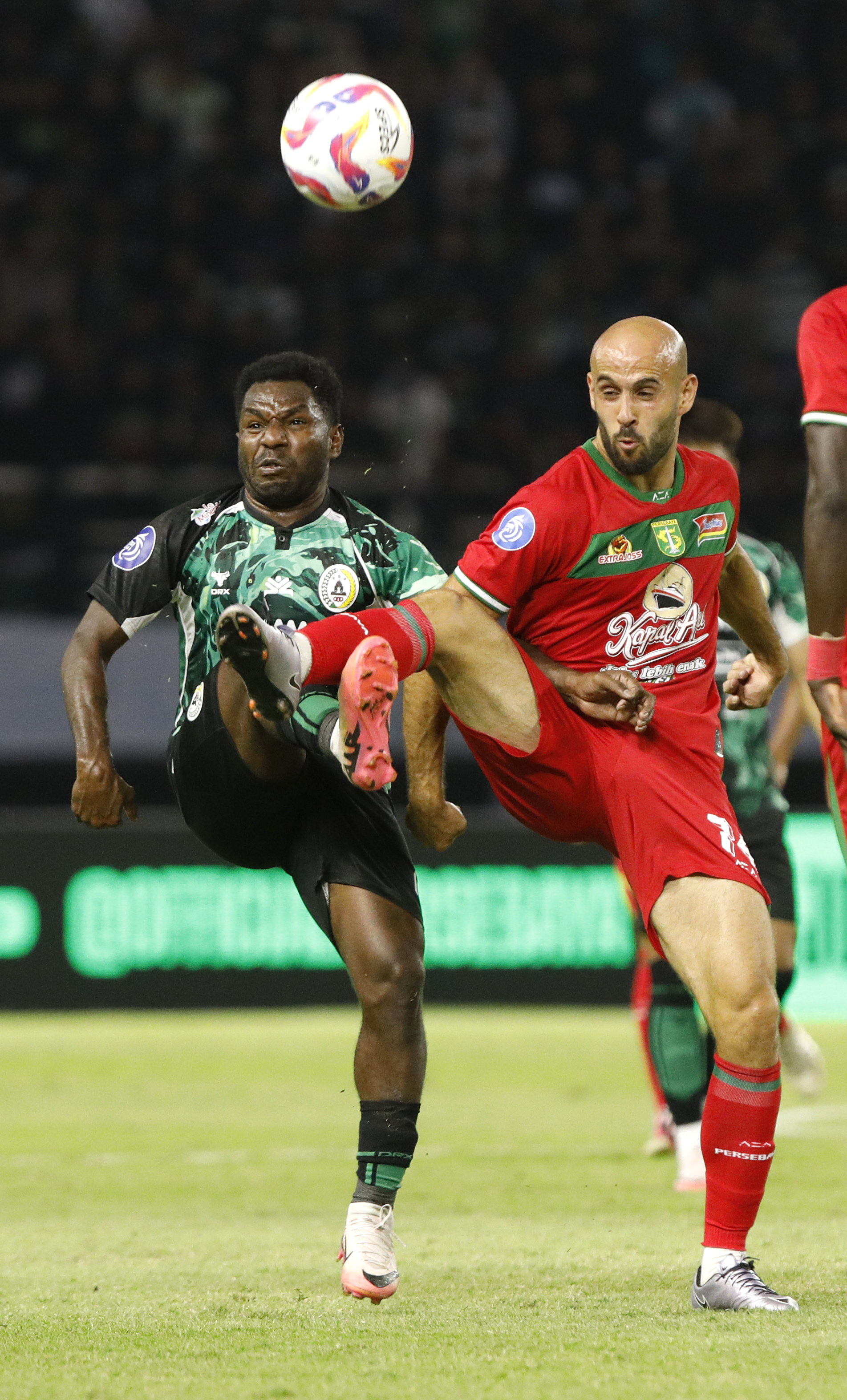 Ricky Cawor berebut bola dengan pemain Persebaya Surabaya, Rashid di laga putaran pertama lalu.