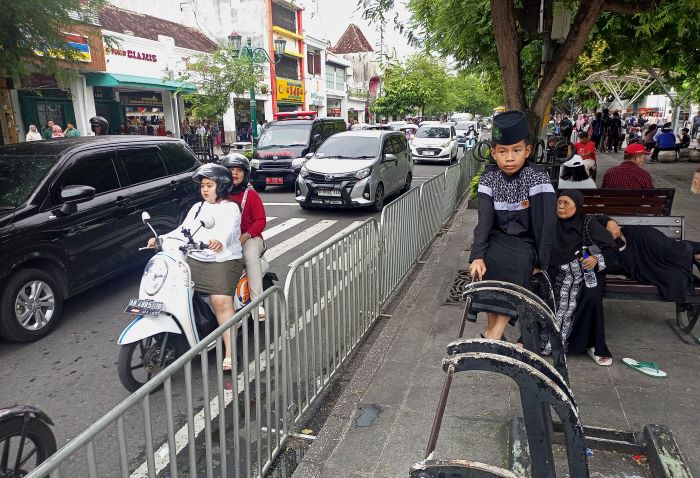 Wisatawan melintas di Jalan Maliobor yang dilengkapi dengan pagar besi, Kota Jogja Senin (30/12/2024).