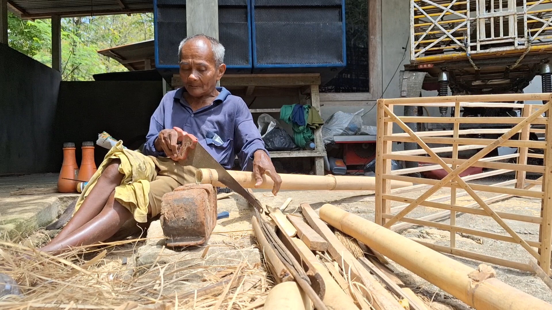 &nbsp;  KETERBATASAN: Mbah Wakiran merangkai kandang ayam di depan rumahnya.