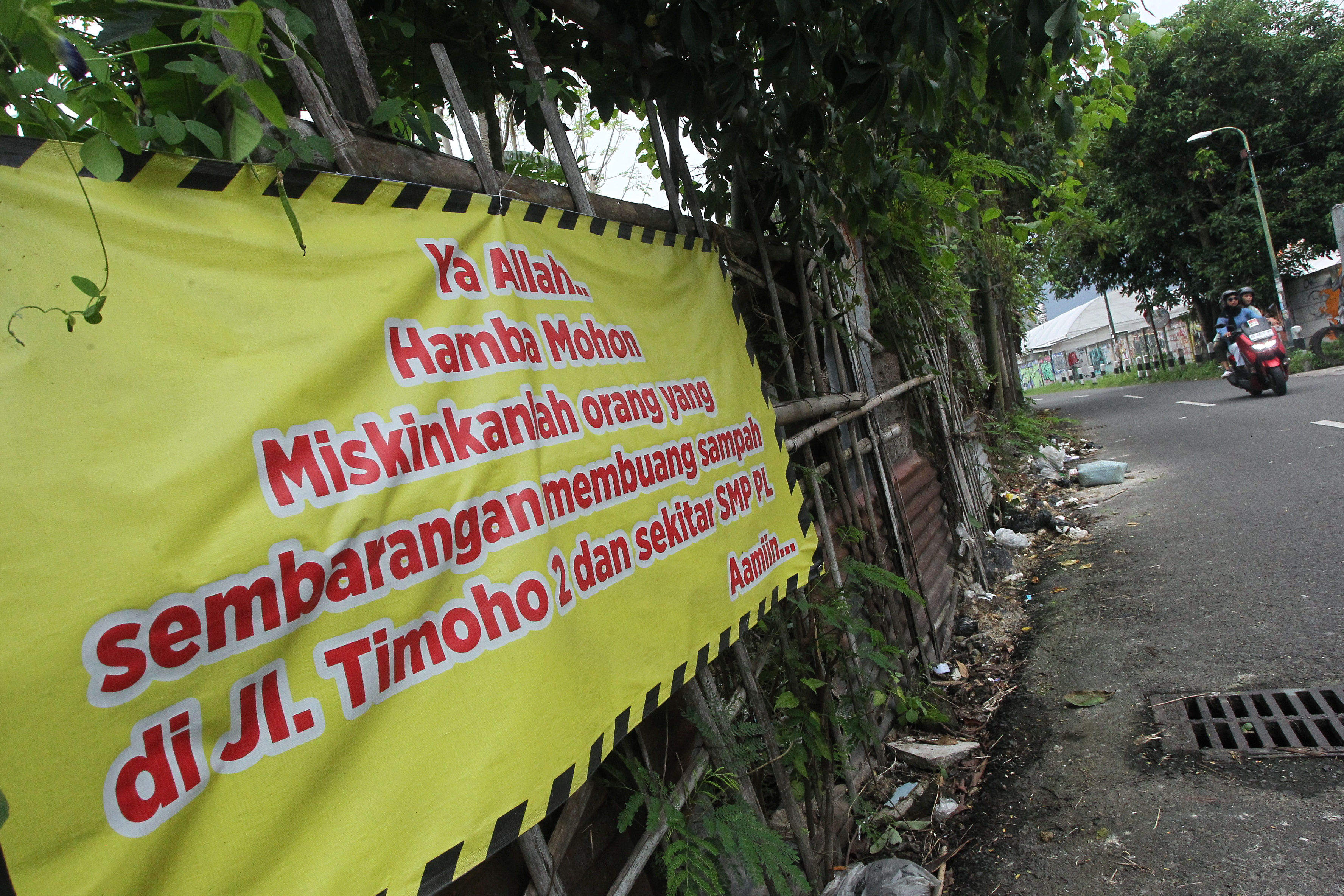 Warga melintas di dekat spanduk larangan membuang sampah sembarangan di kawasan Timoho, Kota Jogja, kemarin (1/1).