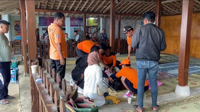 Petugas SAR saat memberikan pertolongan pertama kepada wisatawan yang pingsan di Pantai Watu Kodok, Kapanewon Tanjungsari, Gunungkidul, Rabu (1/1/2025).