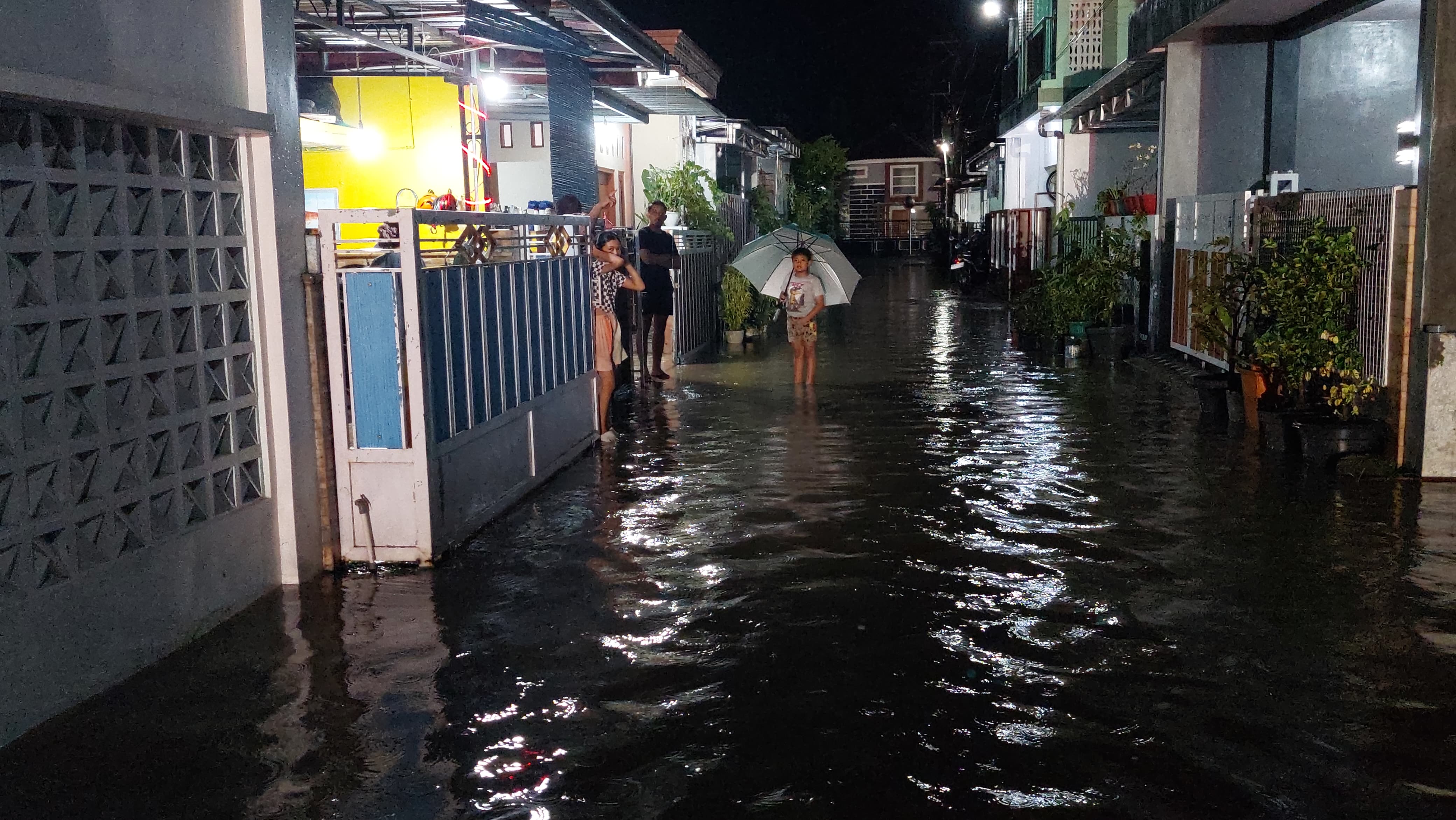 MEMANTAU: Warga sekitar memantau kondisi limpahan air.&nbsp;