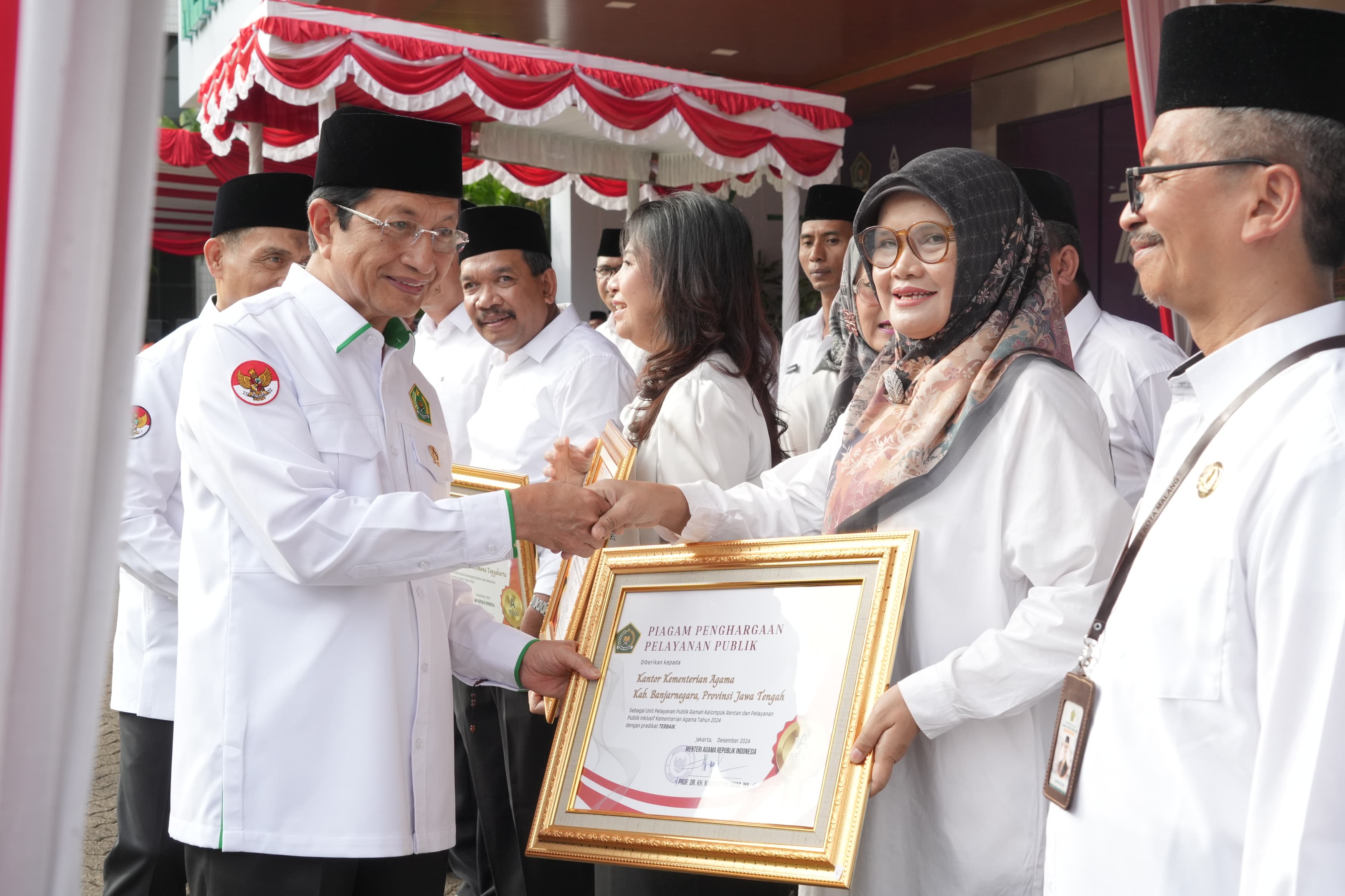 SELAMAT - Menteri Agama Nasaruddin Umar menyerahkan penghargaan WBK kepada Kepala Sekolah MAN 2 Kulon Progo, Hartiningsih, pada Upacara Hari Amal Bakti (HAB) ke-79 di Lapangan Banteng, Jakarta, Jumat