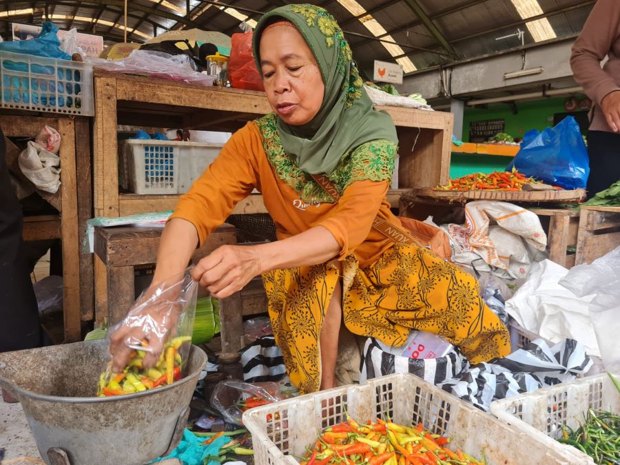 LAYANI PEMBELI: Seorang pedagang di Pasar Rojowinangun, Suruwiyah saat menimbang cabai rawit, Selasa (7/1/2025).