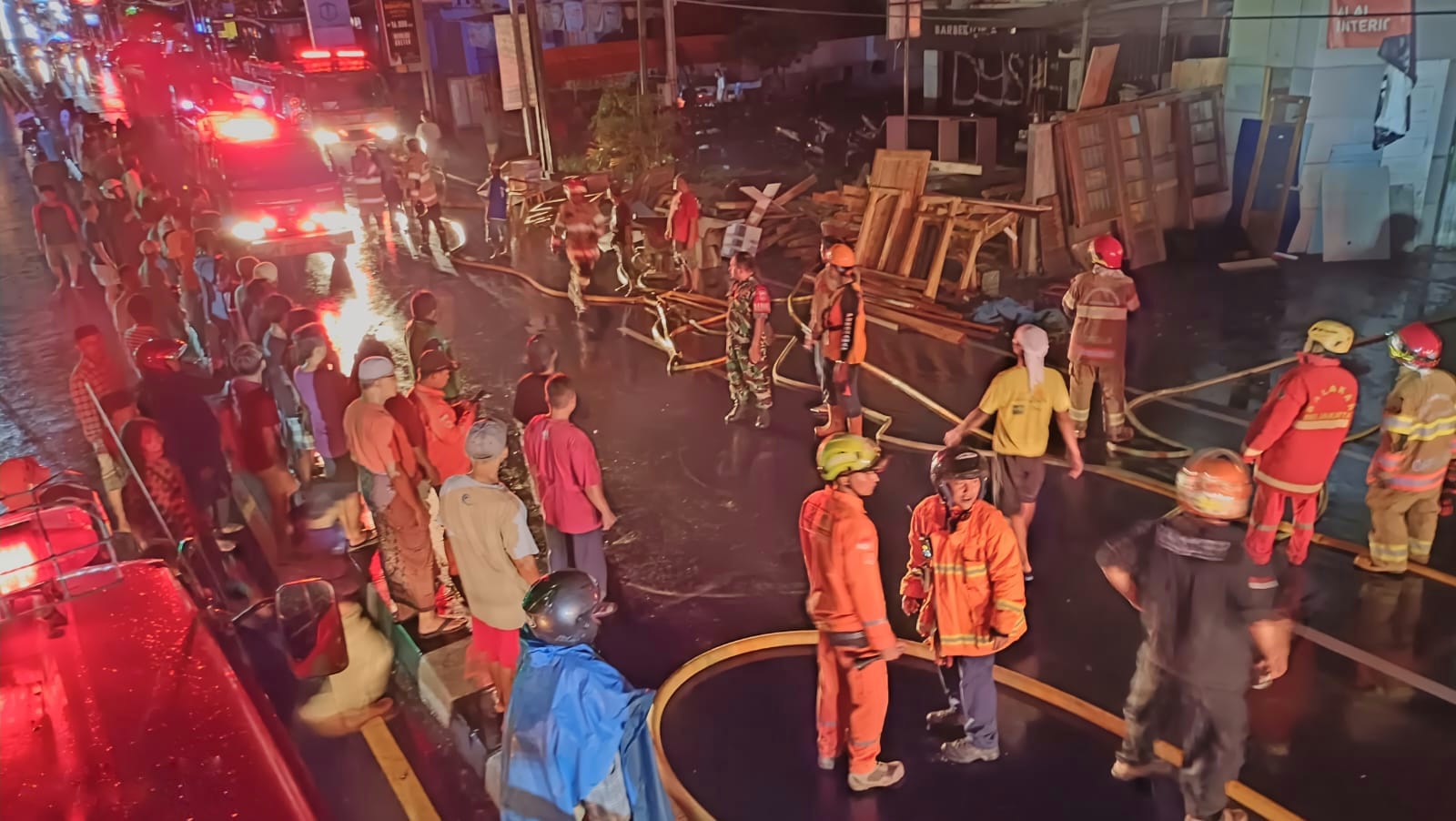 Petugas saat memadamkan api di dua bangunan yang terbakar di Jalan Wates, Kasihan, Bantul, Selasa (7/1/2025) malam. (Dok. Damkarmat BPBD Bantul)