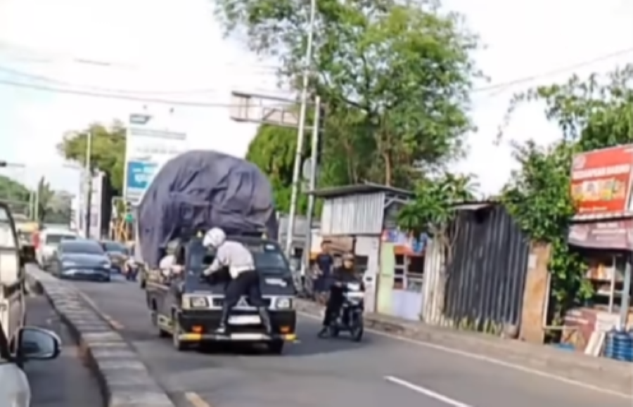 Petugas Dishub saat nyangkut di depan kaca mobil pick up yang hendak diberhentikan karena diduga melanggar.
