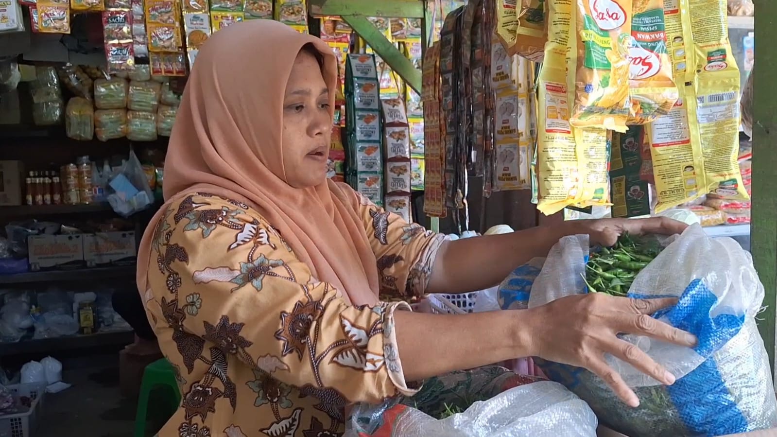 TRANSAKSI: Pedagang Pasar Wates menata barang dagangan sambil melayani pembeli.&nbsp;