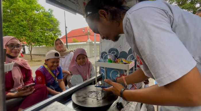 DIMINATI: Tulus Wicaksono saat membuat pancake kartun di sekitar Masjid Gedhe Kauman.
