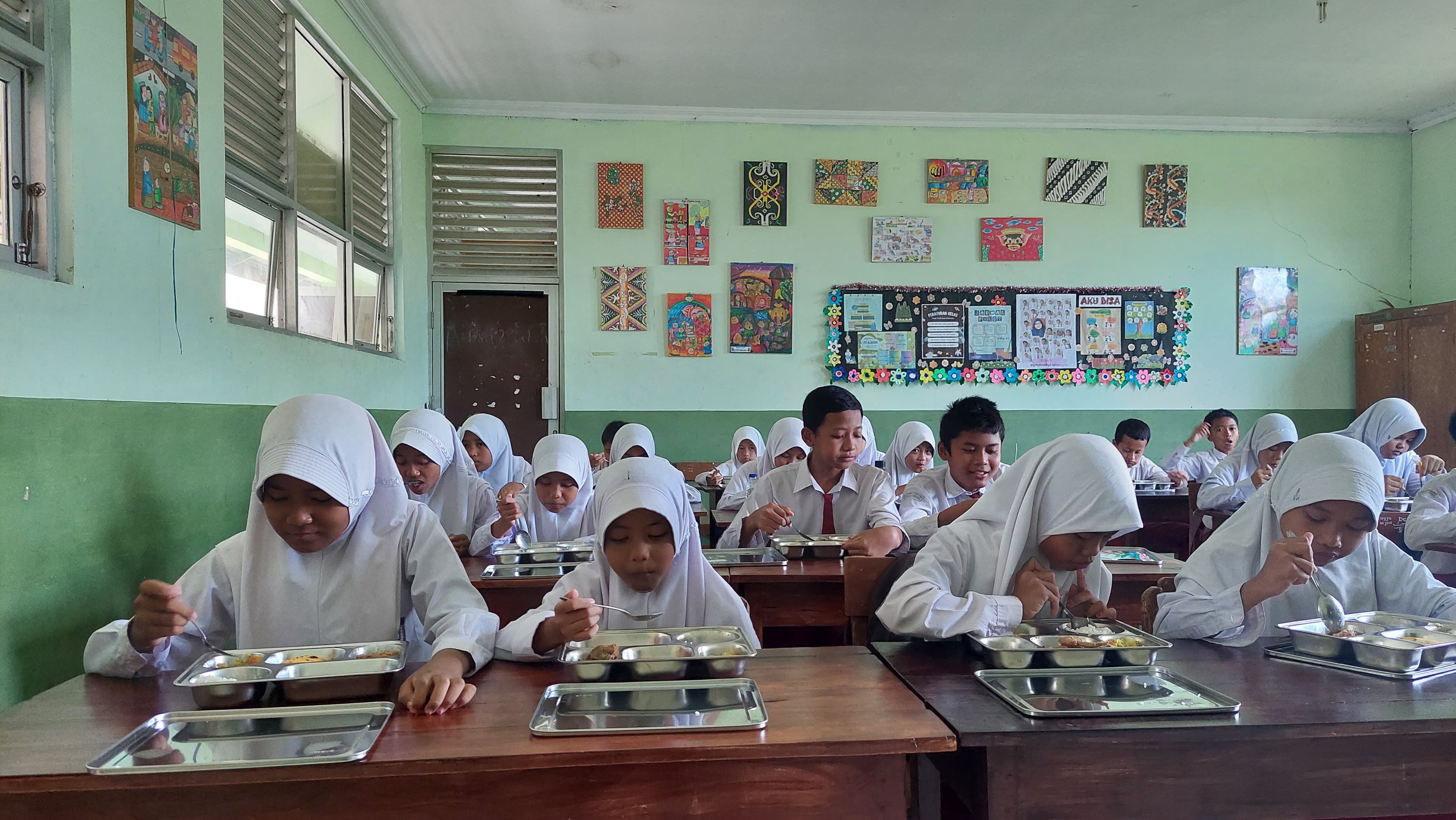 LAHAP: Siswa SD Muhammadiyah Worawari memakan paket makanan dari Program MBG.