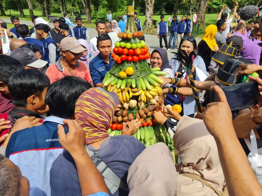 DIPEREBUTKAN: Pengunjung Candi Borobudur memperebutkan gunungan hasil bumi di area Concourse, Senin (13/1/2025).