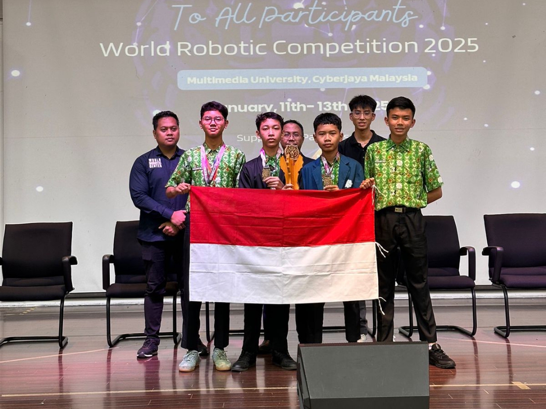 MEMBANGGAKAN : Pelajar MTsN 1 Kebumen membentangkan bendera merah putih usai berhasil keluar sebagai juara dalam ajang International Championship World Robotic Center Competition (WRCC) 2025 di Selang