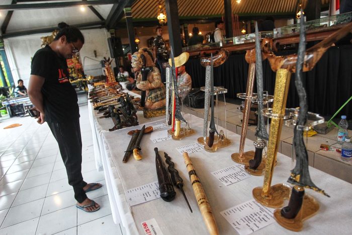 Sejumlah pengunjung mengamati pusaka keris yang dipamerkan dalam pameran Pusoko Ageming Satriyo, di nDalem Yudhonegaran, Kota Jogja, Jumat (17/1/2025).