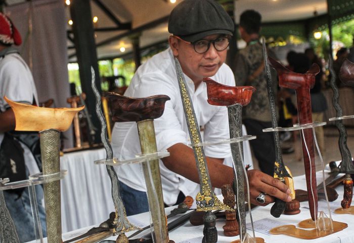 Sejumlah pengunjung mengamati pusaka keris yang dipamerkan dalam pameran Pusoko Ageming Satriyo, di nDalem Yudhonegaran, Kota Jogja, Jumat (17/1/2025).