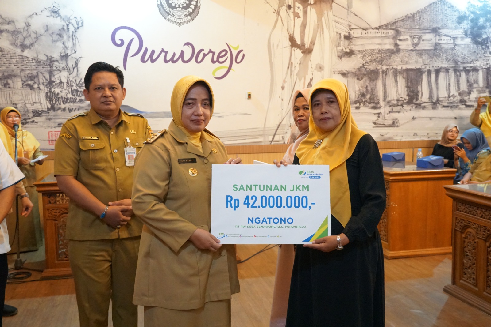 Bupati Purworejo Yuli Hastuti saat menyerahkan santunan Program JKM BPJS Ketenagakerjaan kepada ahli waris dua aparatur desa di Kabupaten Purworejo, Senin (20/1).