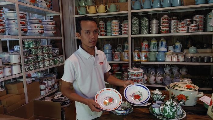 PERBEDAAN: Sukamto menunjukkan perbedaan piring antara keluaran lama (tangan kiri) dengan piring keluaran baru (tangan kanan).