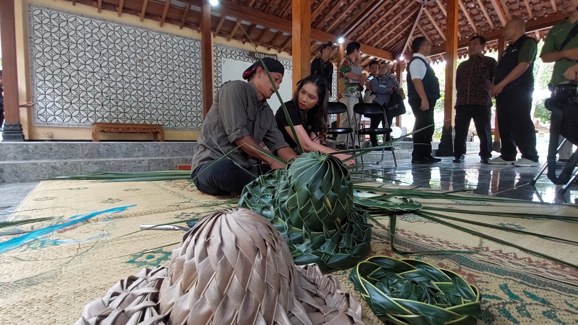 BIKIN TOPI: Wakil Menteri Pariwisata Ni Luh Puspa mencoba membuat topi dari anyaman daun kelapa saat mengunjungi Desa Wisata Tinalah, Jumat (24/1)