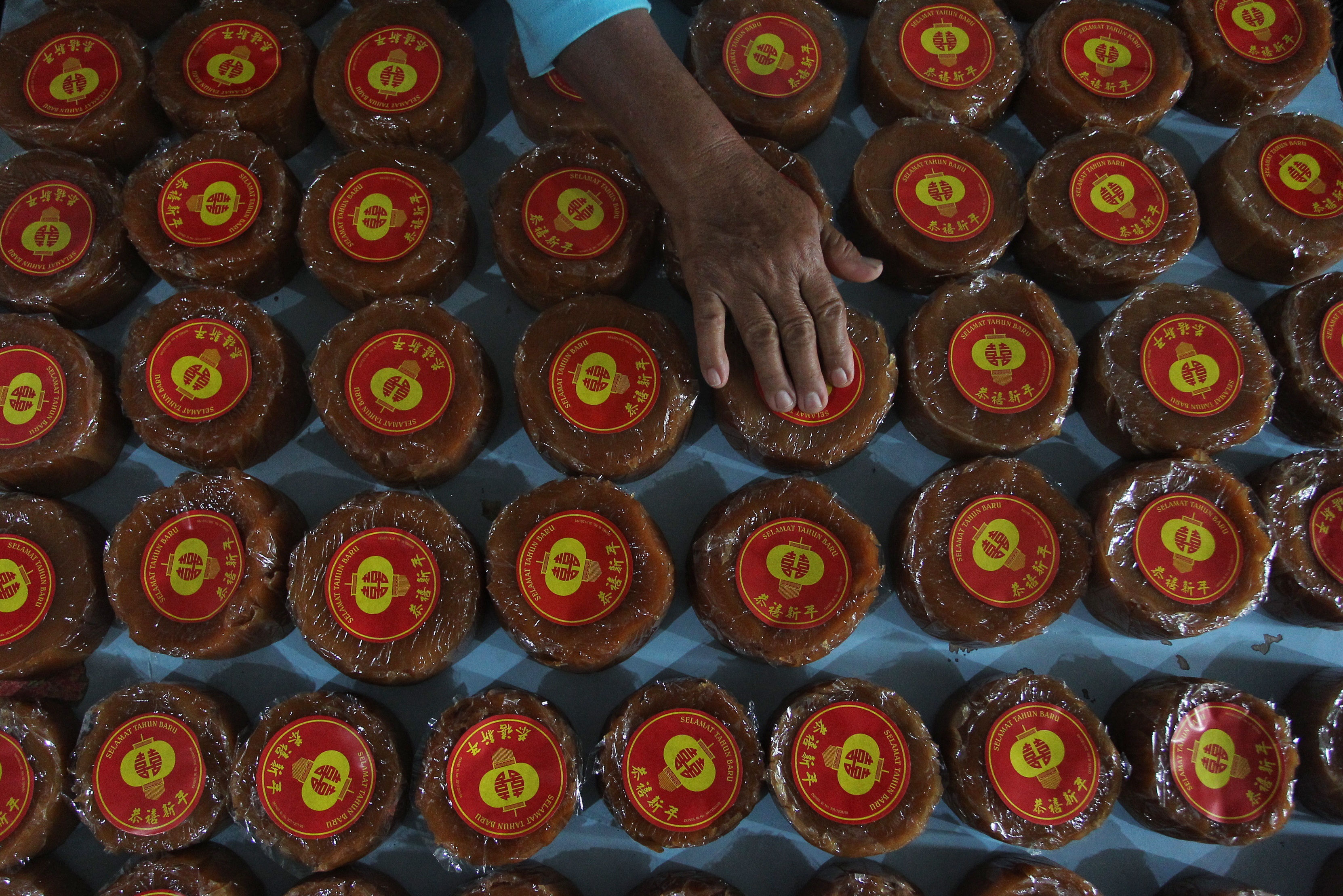 Pekerja menata kue keranjang yang diproduksi di Jalan Tukangan, Kota Jogja, Minggu (26/1).