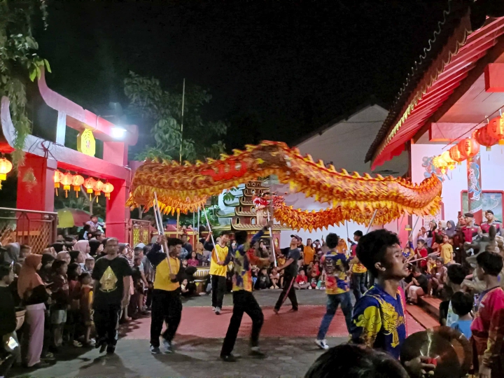 Warga mengantre di depan gerbang Kelenteng Kong Hwie Kiong untuk menanti tradisi pembagian angpau pada perayaan malam Imlek tahun 2025.