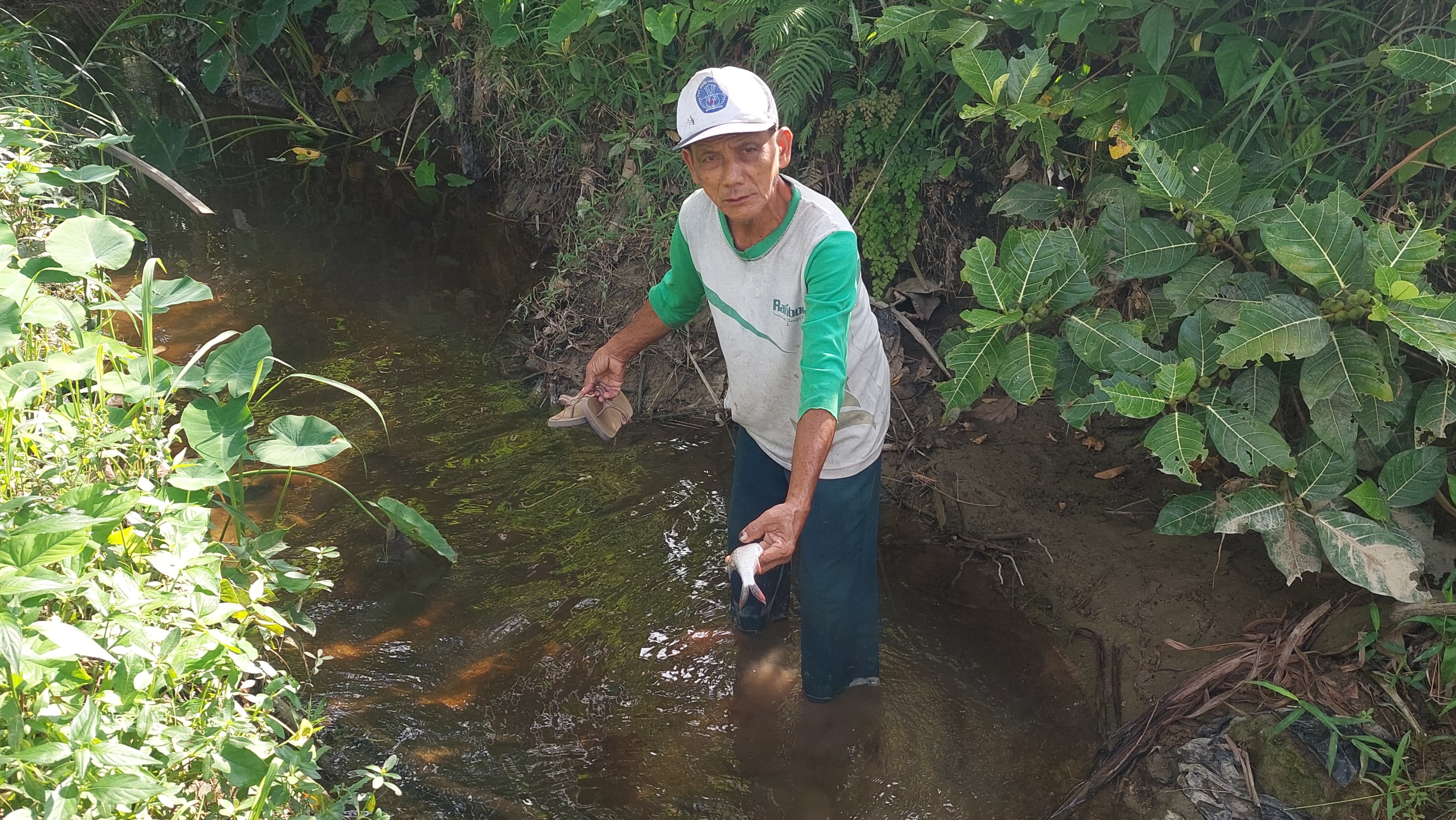 TERCEMAR: Warga menunjukkan ikan mati akibat sungai tercampur lindi.&nbsp;