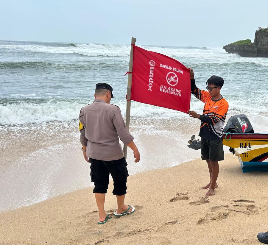 Bendera merah memberitahukan area palung dan larangan berenang yang dipasangan di bibir Pantai Drini, Gunungkidul, Senin (3/2).