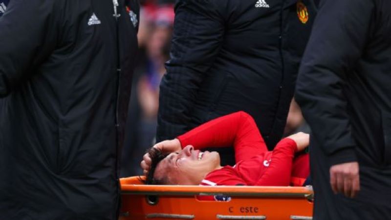 Pemain bertahan Manchester United, Lisandro Martinez saat ditandu keluar lapangan karena cedera (Robbie Jay Barratt - AMA/Getty Images)