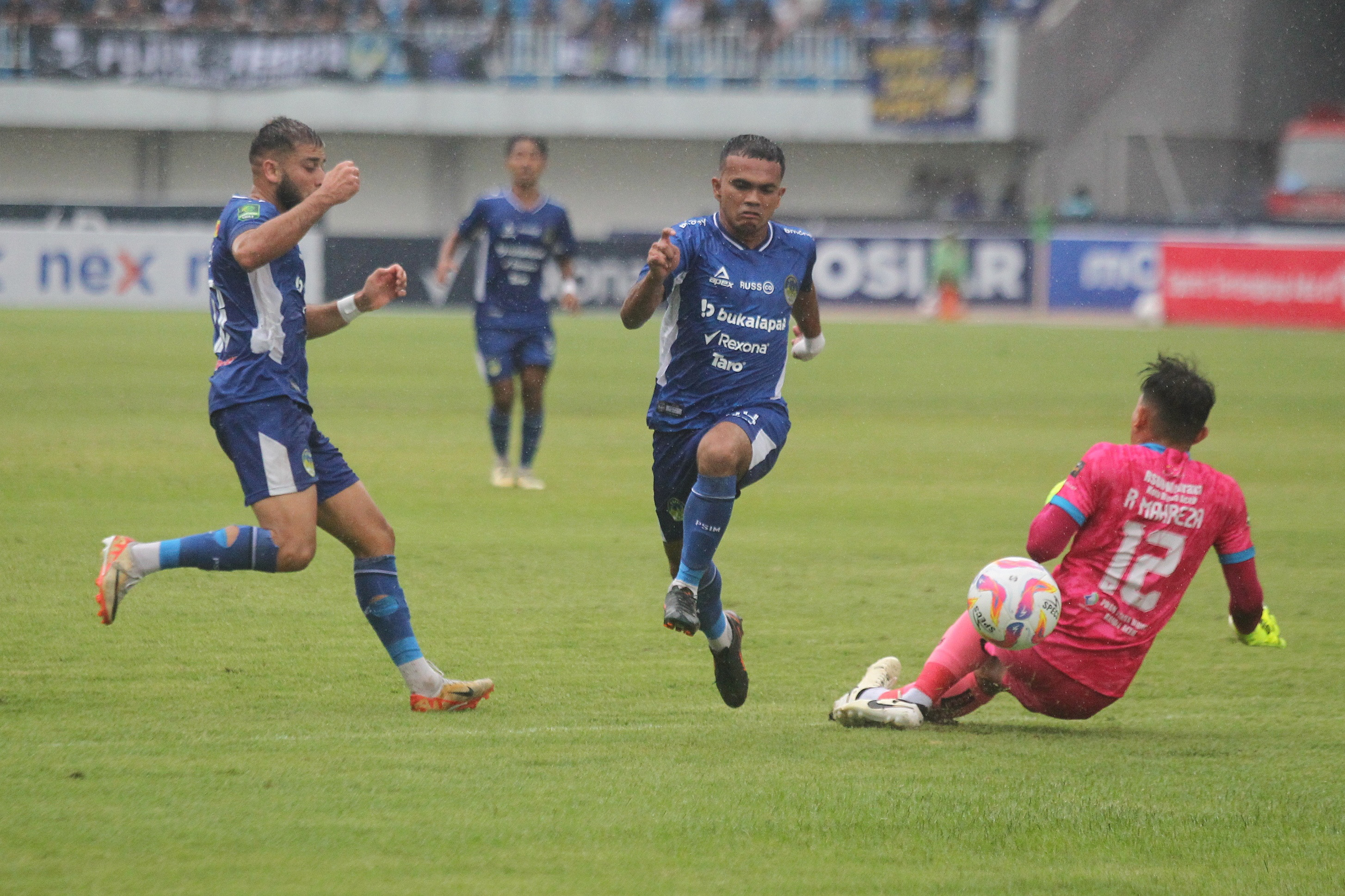 Pemain PSIM Jogja Roken Tampubolon (tengah) dan Omid Popalzay berebut bola dengan kiper Persiraja
